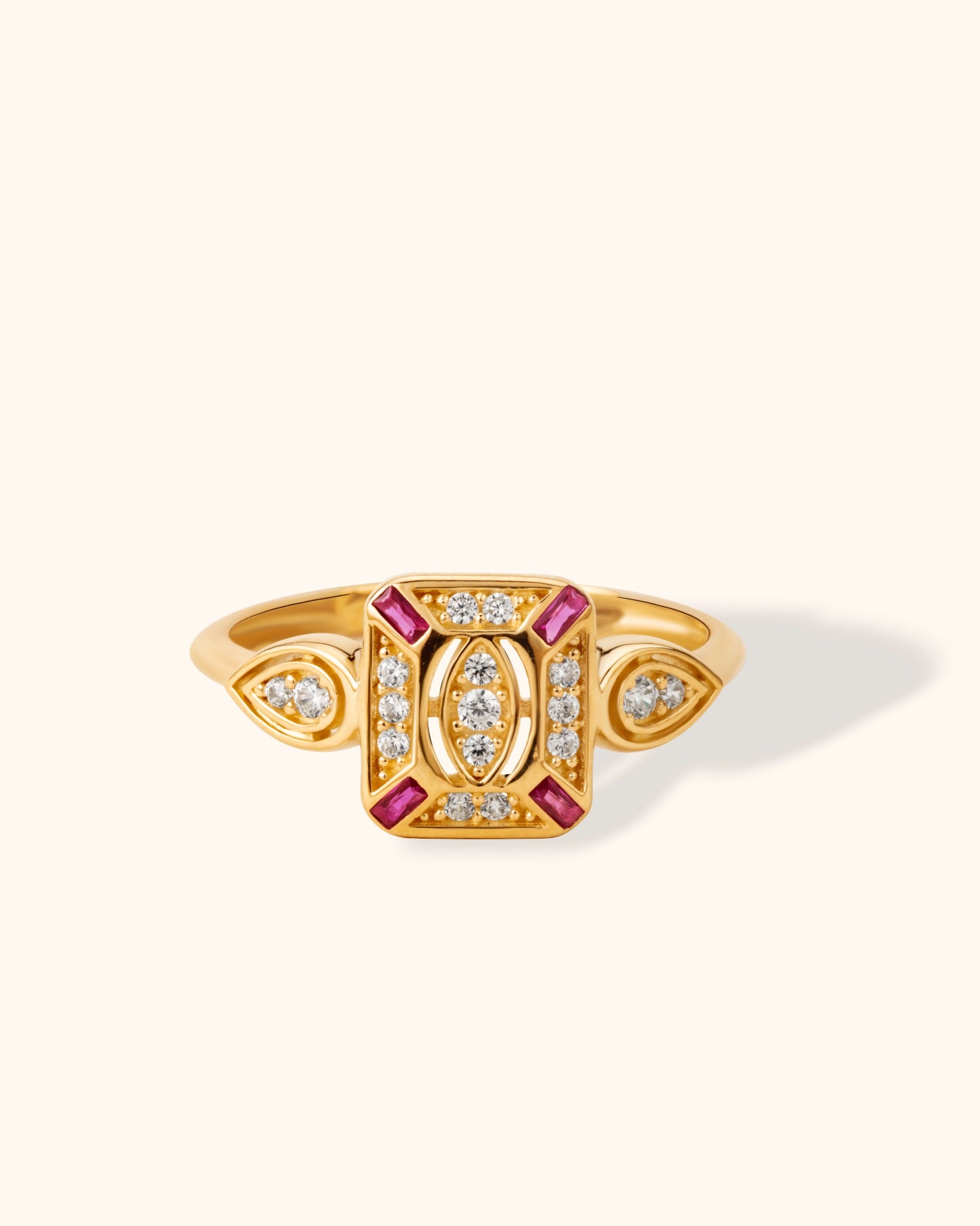 14K gold vintage-style ring with pink baguette stones and white diamonds on cream background.