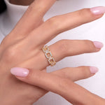 Close-up of a woman's hand wearing a bold 14K gold ring with rectangular baguette-cut and round stones