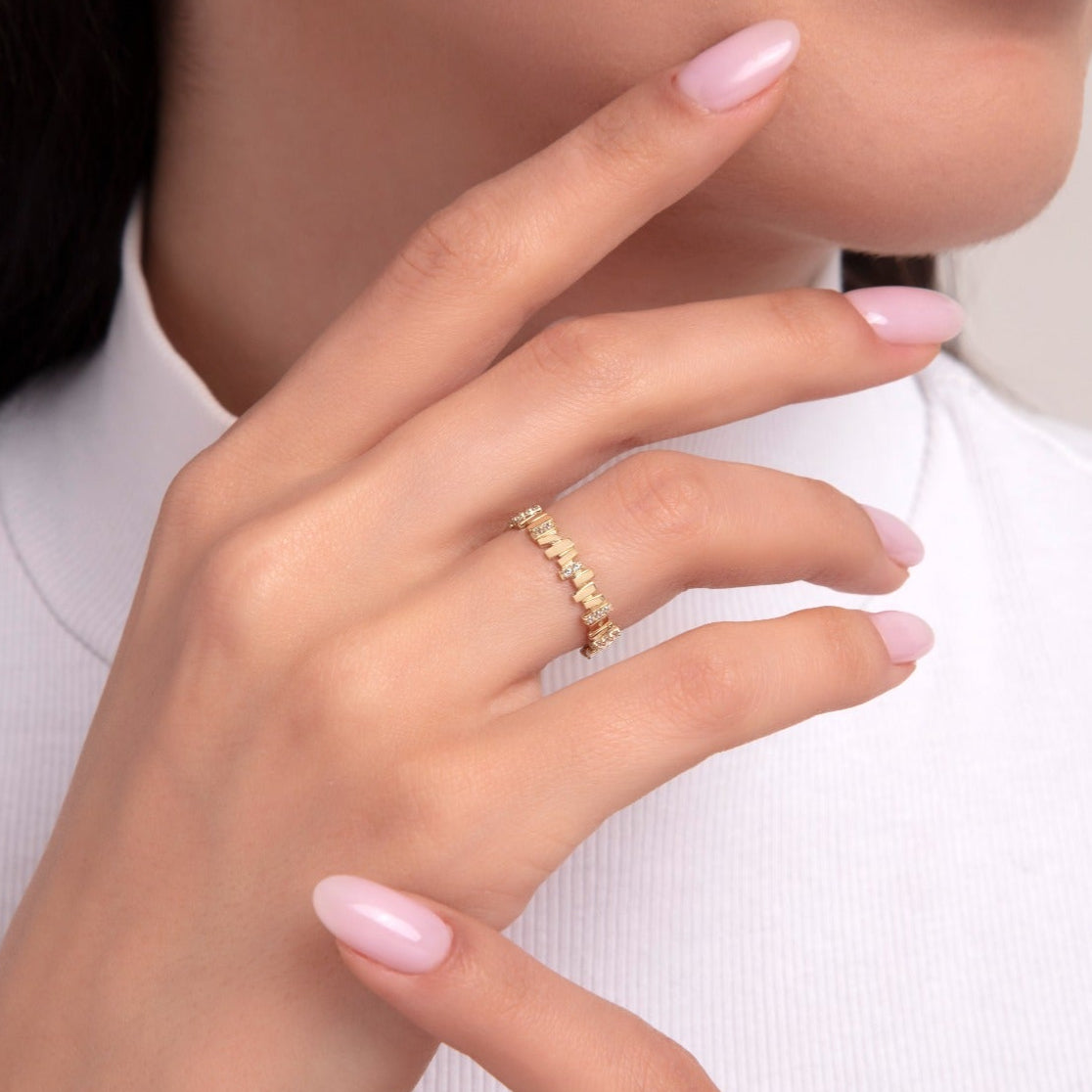 Woman wearing a delicate 14K gold ring with baguette-cut cubic zirconia stones