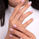 Woman wearing a 14K gold beaded stackable ring on her finger with soft pink manicure