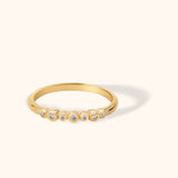 Minimal 14K yellow gold ring featuring a row of bezel-set diamonds