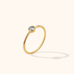 Minimalist 14K gold ring featuring a bezel-set round solitaire stone, perfect for stacking or wearing solo