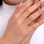 Close-up of a woman's hand showcasing a 14K gold braided rope-style ring on her finger