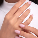 Close-up of a woman's hand wearing a 14K gold ring with a delicate, curved branch-like design