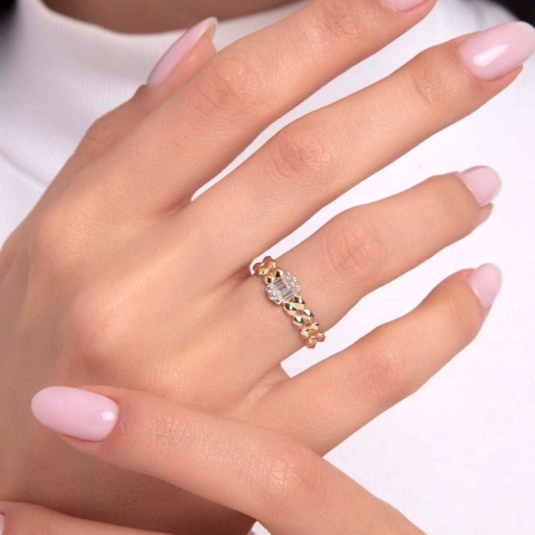14K gold chain ring featuring a central baguette diamond cluster on model’s hand