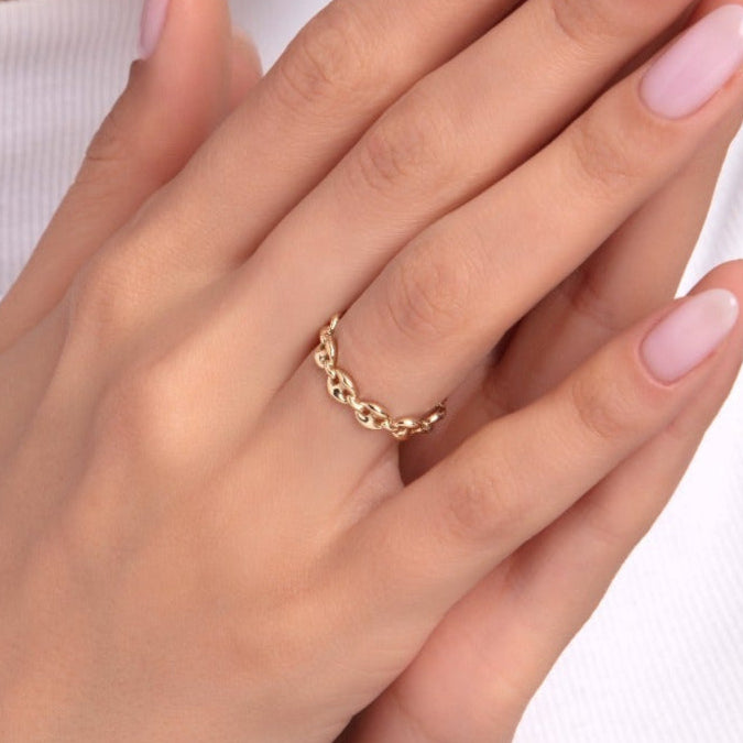 Woman’s hand wearing a delicate 14K gold chain link ring with minimalist style