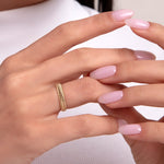 Close-up of a woman's hand wearing a 14K gold ring with a chevron-beaded texture, perfect for stacking