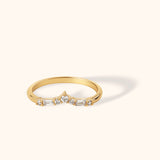 Chevron-shaped 14K gold ring featuring baguette and round zircon stones in a delicate curved design