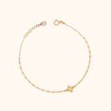 Minimal 14K gold bracelet with four-leaf clover charm on a delicate patterned chain