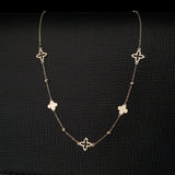 14K gold necklace with alternating solid and open clover charms on a delicate chain