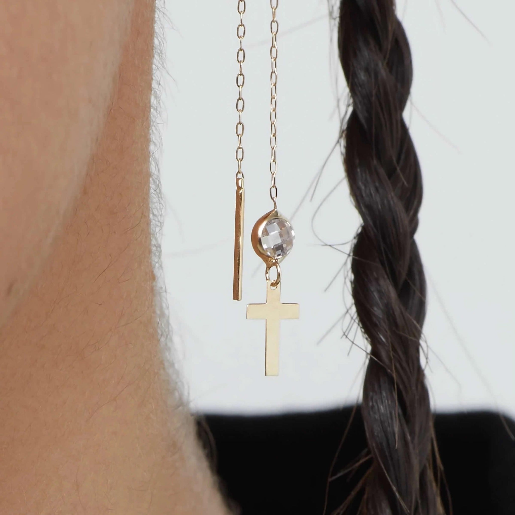 14K gold threader earrings with cross charm and clear crystal bead on model