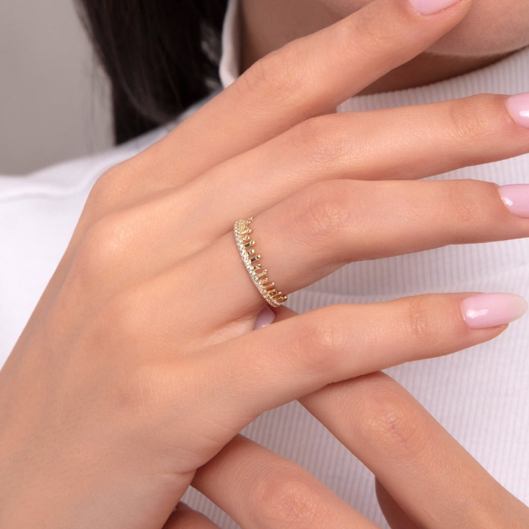 Elegant woman wearing a 14K gold tiara-style ring with tiny zircon stones arranged in a crown silhouette