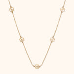 14K gold necklace with open flower station charms evenly spaced on delicate chain
