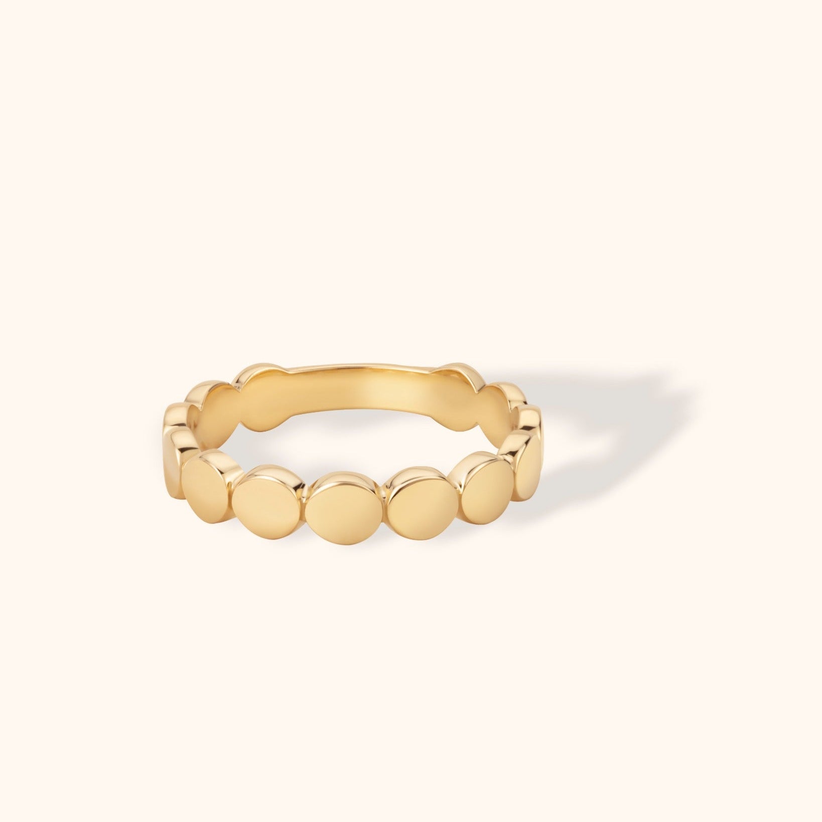 Elegant 14K gold ring featuring a continuous row of smooth round disc elements in a minimalist eternity band design