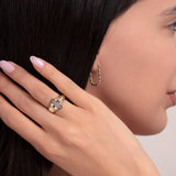 Side view of a woman wearing a bold dome-shaped 14K gold ring with horizontal diamond and black enamel accents
