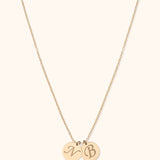 14K gold necklace with two engraved initial discs on delicate chain