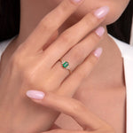 Model wearing a 14K gold ring with a baguette emerald and diamond accents.