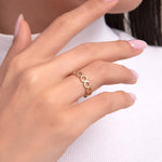 Woman wearing a 14K gold ring with honeycomb-inspired geometric cutouts