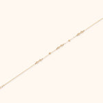 14K gold infinity chain bracelet with bead accents on white background