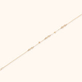 14K gold infinity chain bracelet with bead accents on white background