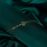 14K gold bracelet with lotus flower charm and faceted gemstone beads on emerald green satin background