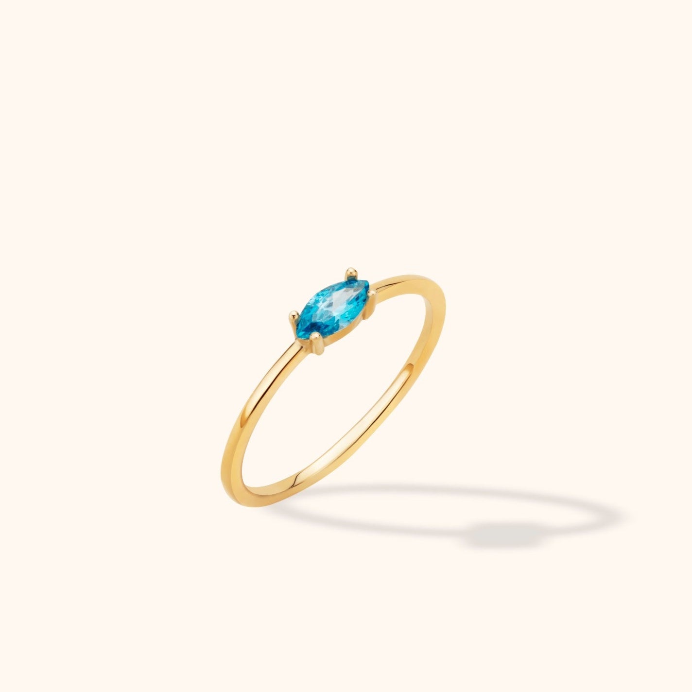 Minimalist 14K gold ring with marquise-cut blue stone, perfect as engagement or stacking band