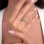 Model wearing a 14K gold ring with marquise emerald stones and white zircons in a crown-leaf design