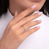 Woman's hand wearing a 14K gold ring with alternating marquise and round-cut stones, styled with pastel nails and white turtleneck.
