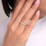 Woman wearing a 14K gold ring with a full band of matte-finished circular dots