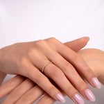 14k gold minimalist ring with a fine diamond accent worn on hand

