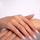 14k gold minimalist ring with a fine diamond accent worn on hand

