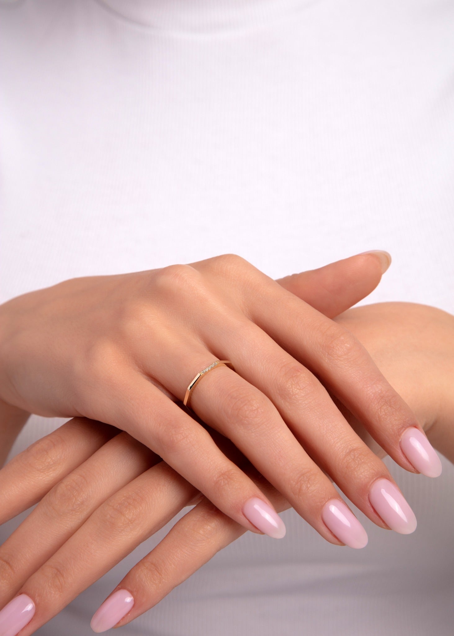 14k gold minimalist ring with a fine diamond accent worn on hand

