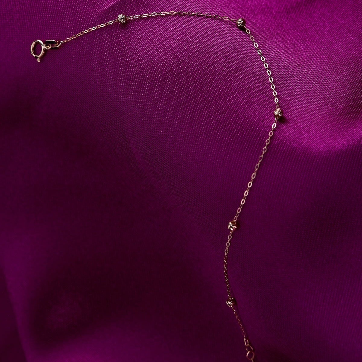 Minimal 14K gold bracelet with small Dorika beads on purple satin
