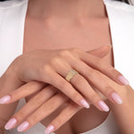 Woman showcasing a 14K gold ring with vertical baguette-style bar details arranged in a stepped modern silhouette