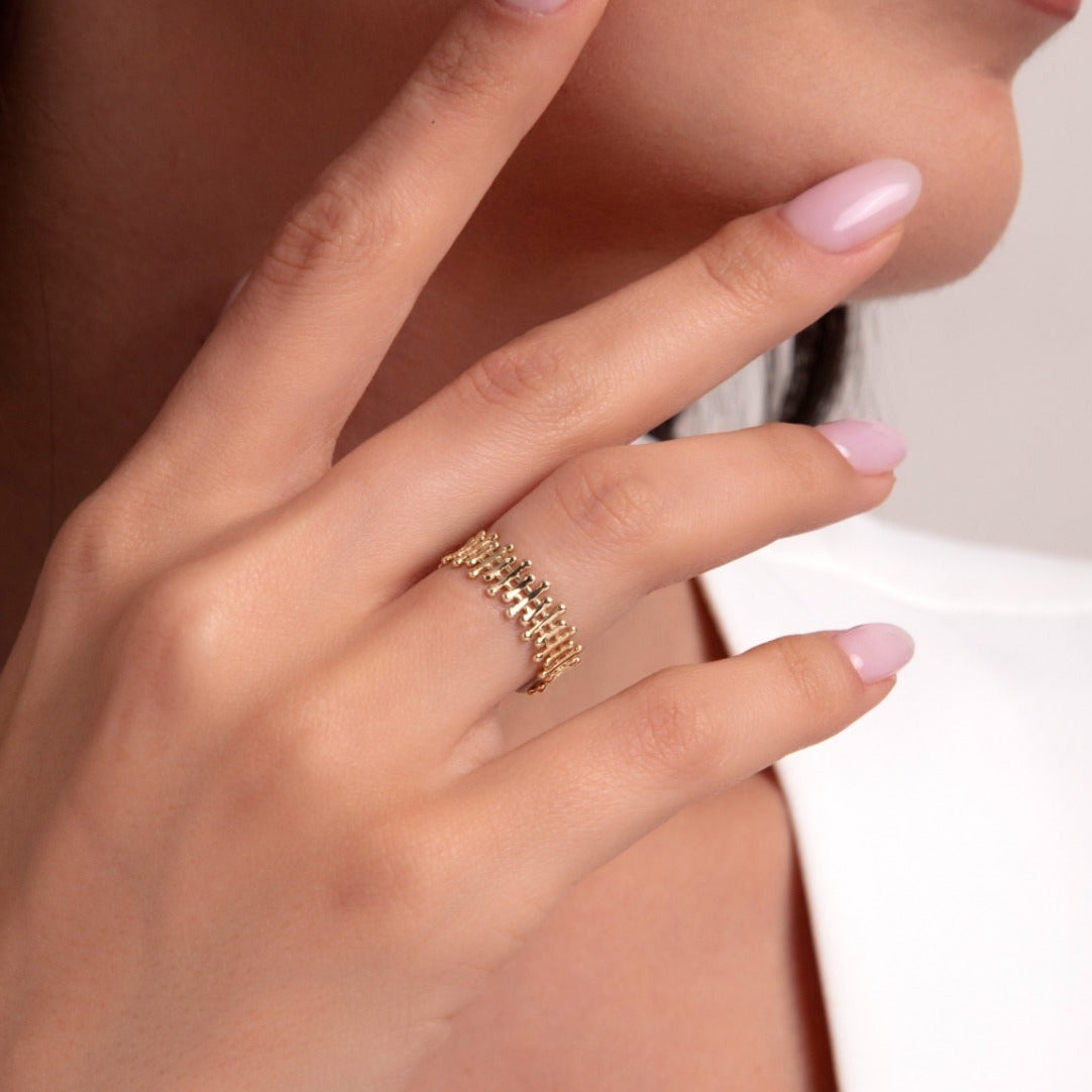 Close-up of a woman wearing a stylish 14K gold chain-link ring on her hand