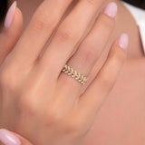 Close-up of a 14K gold ring with open leaf design and white marquise zircon stones on a woman’s hand