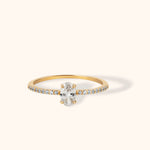 Elegant 14K gold ring featuring an oval cut white center stone with pavé side accents on a slim band