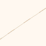 Solid 14K gold paperclip chain bracelet with minimalist link design on white background