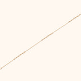 Solid 14K gold paperclip chain bracelet with minimalist link design on white background