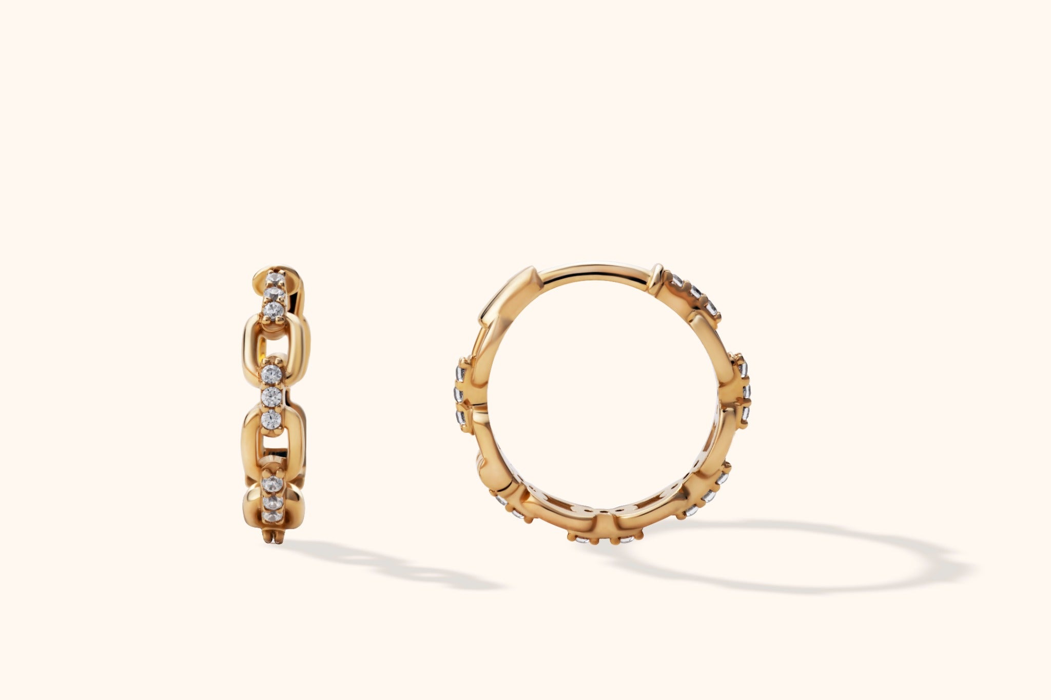 Close-up of 14K gold pavé chain link hoop earrings with mini huggie silhouette and CZ stones, shown front and side view