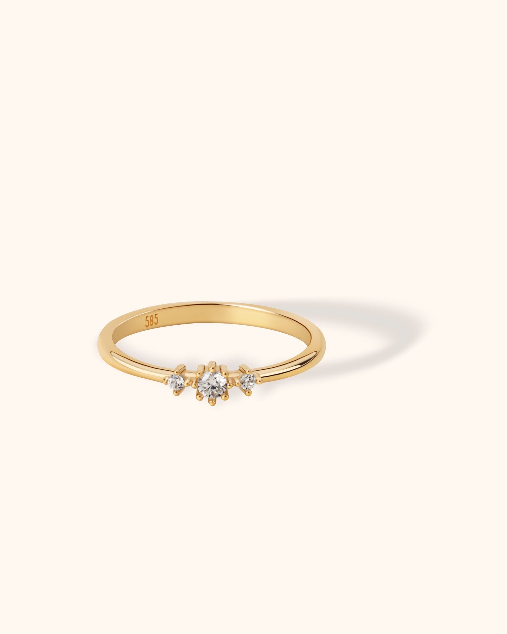 Slim 14K gold ring featuring a central diamond with two smaller side stones in a balanced cluster design