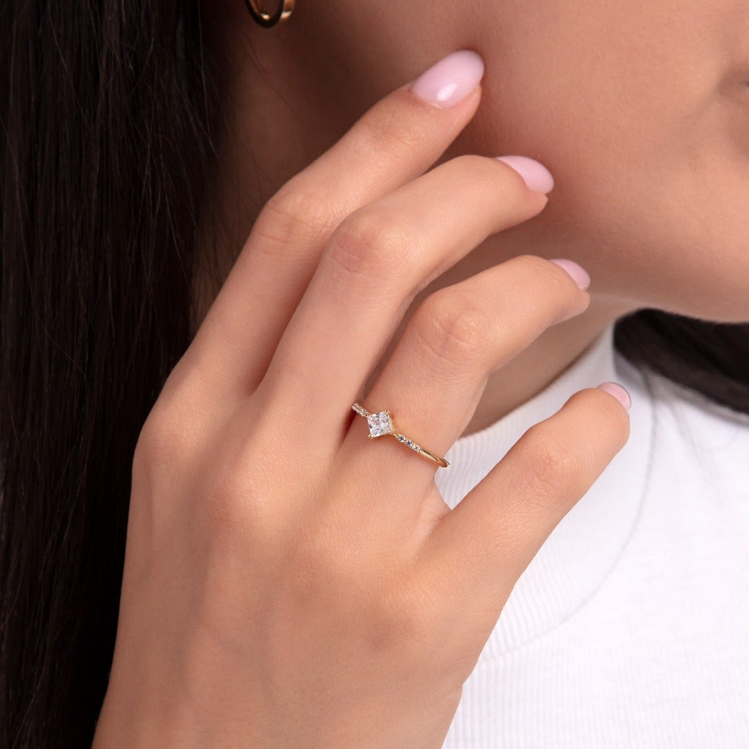 Gold ring with princess cut square stone worn on hand, elegant and minimalist engagement ring design