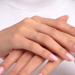 Minimalist gold ring with pyramid dot pattern on woman’s hand, styled with light pink manicure