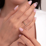 Woman wearing a 14K gold rainbow gemstone ring on her finger with a close-up of her hands