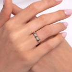 Woman wearing a 14K gold ring with colorful pavé stones including white, green, pink, and blue