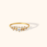 Delicate 14K gold ring featuring a central round stone with clustered side stones in a celestial-inspired design
