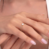 14K gold ring with round opal on a beaded band worn on a woman’s hand