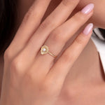 14K gold ring with seashell design and center pearl, worn on hand with natural light