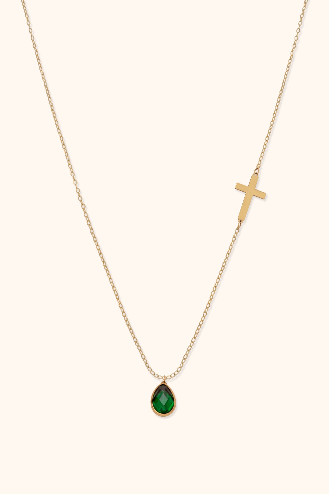 Elegant 14K gold necklace with sideways cross and green teardrop gemstone pendant