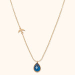 14K gold necklace with blue gemstone teardrop pendant and gold bird charm